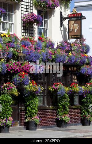 `The Churchill Arms` Pub in der Kensington Church Street, bedeckt mit Sommerblumen, London, Großbritannien Stockfoto